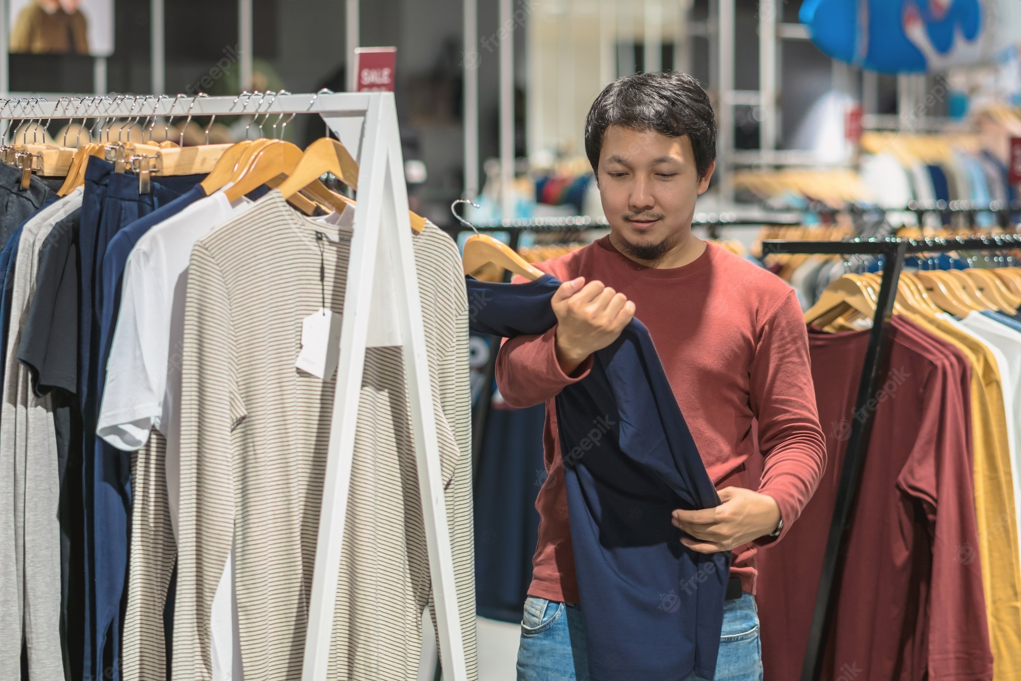 Premium Photo | Smart asian man with beard choosing clothes in clothing store at shopping center